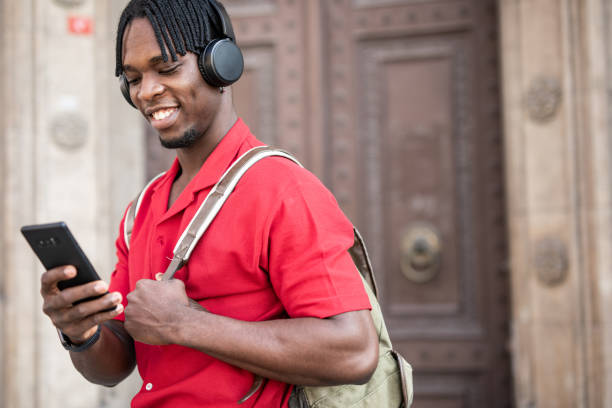 istock Portrait of a handsome afro man using modern contemporary technologies, phone and wifi wireless headphones 1349490133