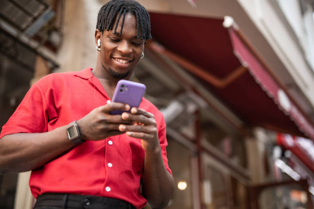 istock Portrait of a handsome afro man using modern contemporary technologies, phone and wifi wireless headphones 1349490139
