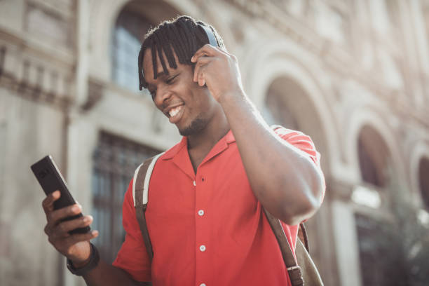 istock Portrait of a handsome afro man using modern contemporary technologies, phone and wifi wireless headphones 1349490144