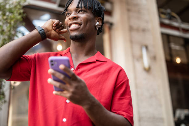 istock Portrait of a handsome afro man using modern contemporary technologies, phone and wifi wireless headphones 1349490146