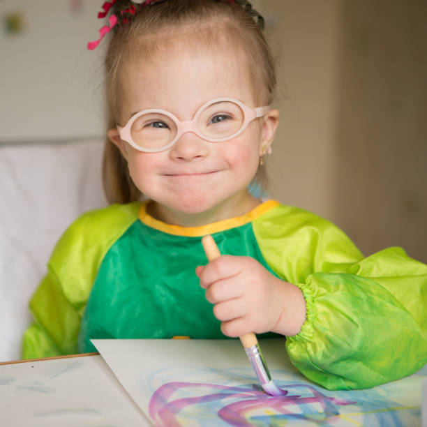 девушка с синдромом дауна покрыта краской при рисовании - child art paint humor стоковые фото и изображения