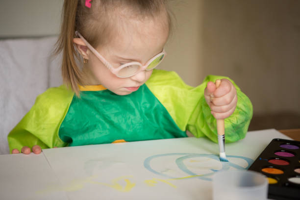 istock Girl with Down syndrome covered in paint when drawing 1349490168