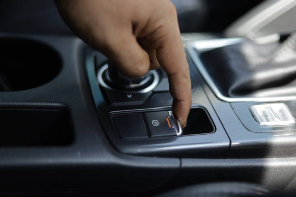 istock hand activates the electric brake in a car while parking 1349490288