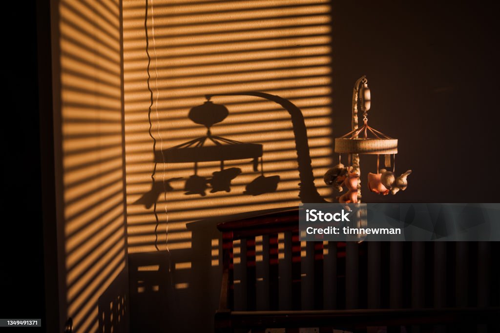 Baby Bedroom Baby Mobile and shadow above a baby crib in the bedroom Crib Stock Photo