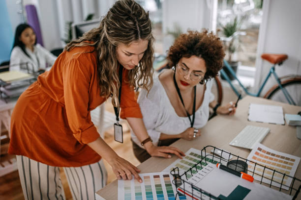 istock Two business colleagues looking at color swatch on table at office 1349492259