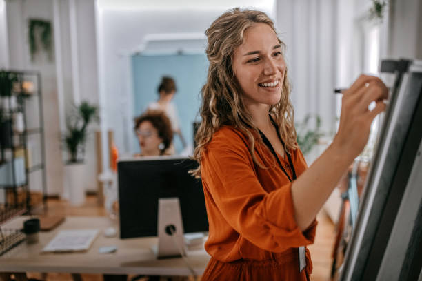 istock Young businesswoman writing on whiteboard at office 1349492436