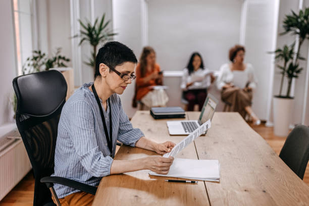 istock Businesswoman reading documents while sitting on chair at office 1349494512