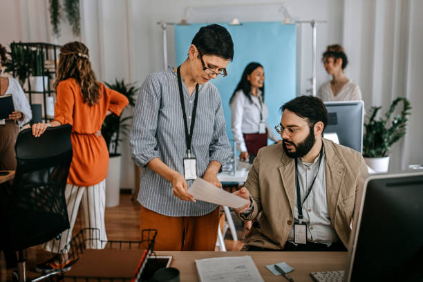 istock Two business colleagues discussing over document at office 1349496751
