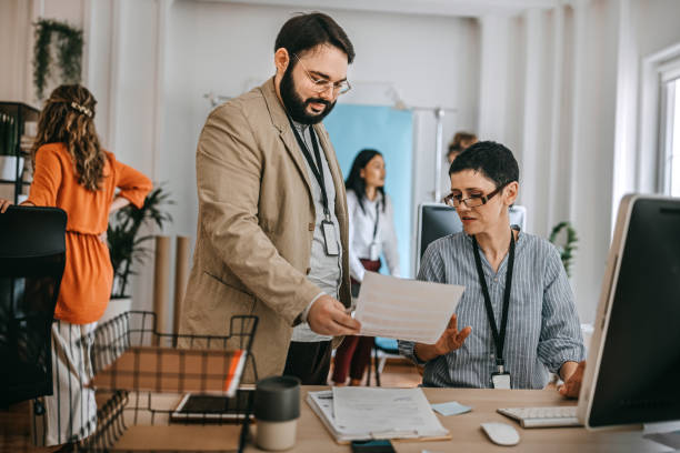 istock Businessman showing document to colleague at office 1349496798