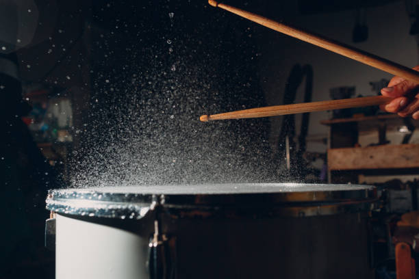 istock Drum sticks drumming beat rhythm on drum surface with splash water drops 1349503265