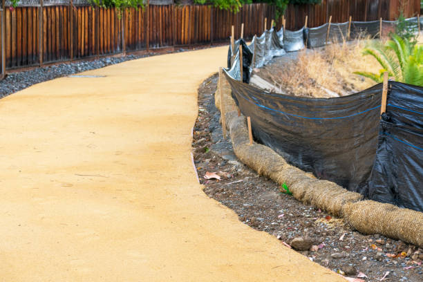 Straw wattle and plastic fence are placed along the waterway to reduce soil erosion, debris runoff and retain sediment during pedestrian trail construction and maintenance project. la zarza de paja y la cerca de plástico se colocan a lo largo de la vía fluvial para reducir la erosión del suelo, la escorrentía de escombros y retener los sedimentos durante la construcción y el proyecto de mantenimiento del sendero peatonal.