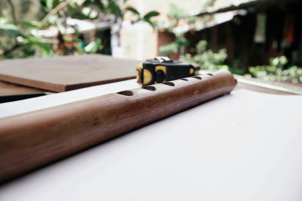 side view of flute built in wood on a table with tools around it