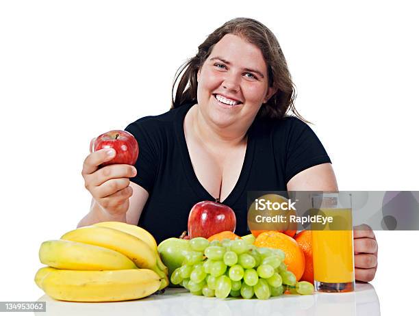 Plump Young Woman Looks Up Smiling From Choice Of Fruit Stock Photo - Download Image Now