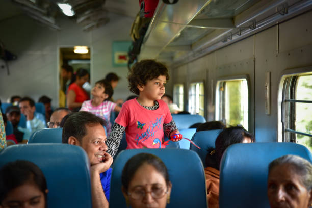 A girl and her father on the train looking outside the window in India stock photo