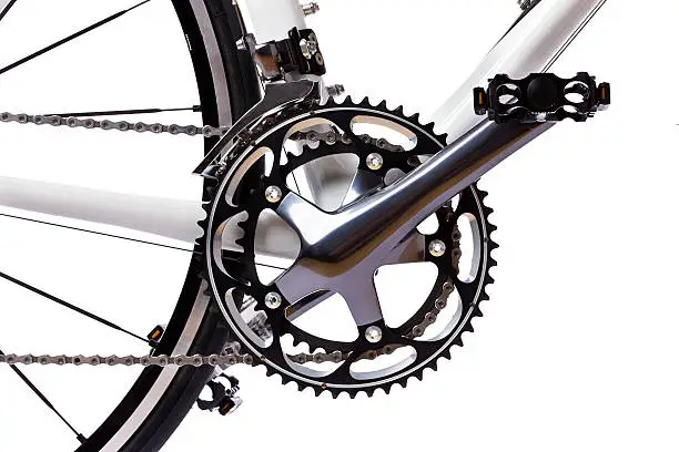 Pedal, crank, front sprockets and derailleur shot on a white background in the studio. The bike is a brand-new top model worth thousands of dollars. Camera: Canon EOS 1Ds Mark III.