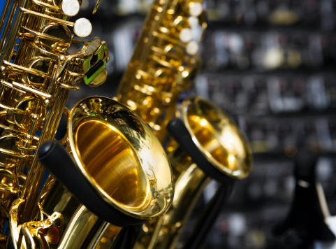 A pair of saxes on stands in a music store. 