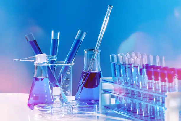 Photo of Collection of medical flasks on a blue background.Science glass flask blue chemistry laboratory banner background. Concept of medicine.