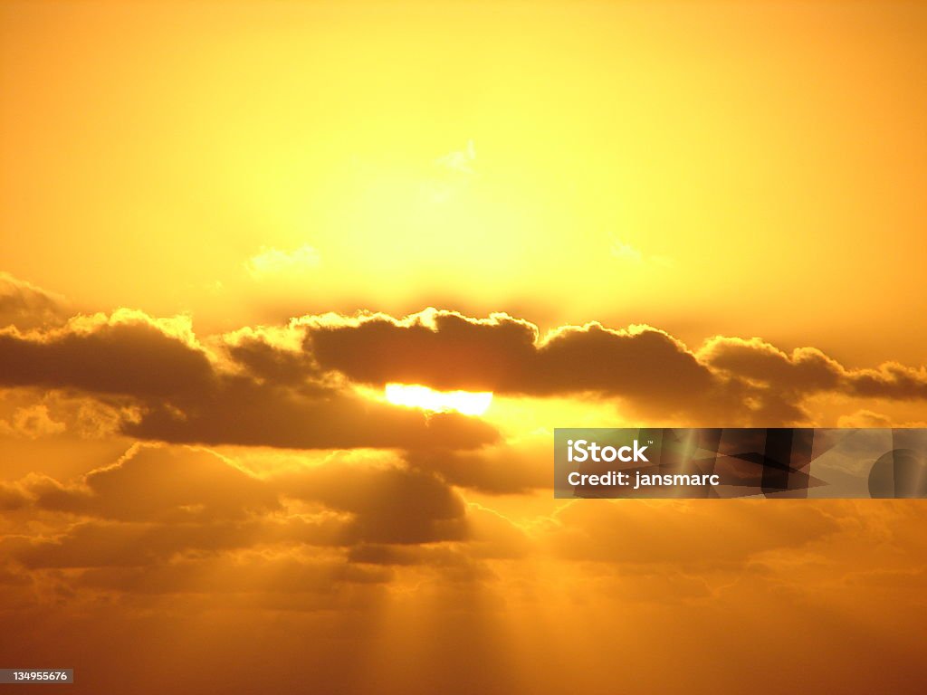 Solar Energy Show Brilliant yellow sunrise with golden sun peeking through morning clouds Cloudscape Stock Photo