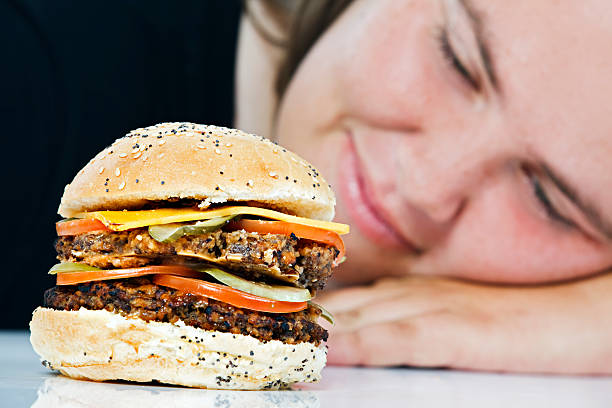 prenez un hamburger être examiné longingly par ses femme - longingly photos et images de collection