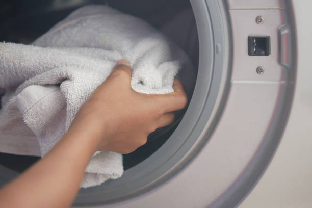 istock putting towel and cloths in a washing machine. 1349559819