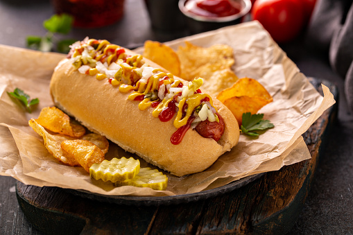 Traditional american hot dog with mustard, ketchup and relish