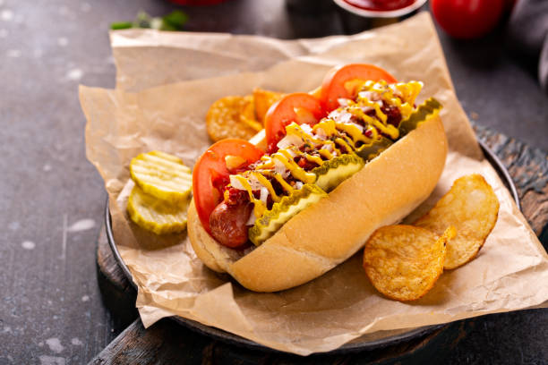 istock Hot dog with tomatoes, mustard and pickles 1349560410