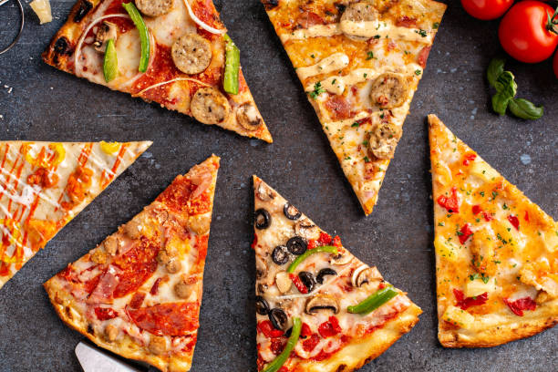 Variety of pizza slices top view on dark background Variety of pizza slices with vegetarian, meat, hawaiian top view pizza stock pictures, royalty-free photos & images