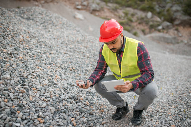 istock A quarry worker examining a stone he has found and searches the internet to find out something about it 1349561777