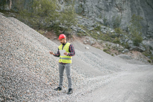 istock Bearded worker with helmet standing in front of the tunnel and using computer 1349564510