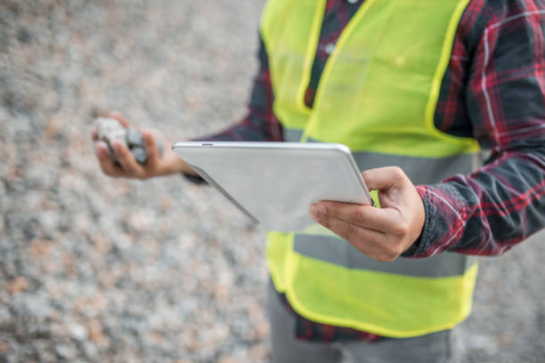 istock Close-up of engineer in quarry holding digital tablet and stones 1349566049