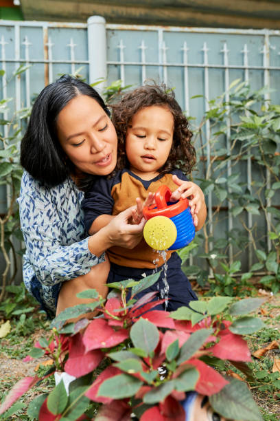 istock Mother and Son Watering Plants 1349575683