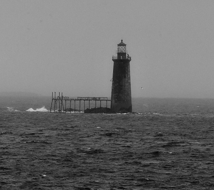 Lighthouse piercing light thru winter storm