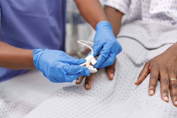 입원 한 환자에 맥박 산소계를 사용하여 간호사 - 산소 포화도 측정기 뉴스 사진 이미지