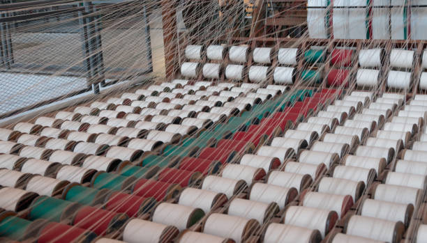 Old loom, spinning machine, rows of white and colored cotton threads Old loom, spinning machine, rows of white and colored cotton threads- carpet factory stock pictures, royalty-free photos & images