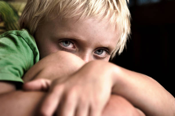 Depressed 6 years old child crying. Dark background.
