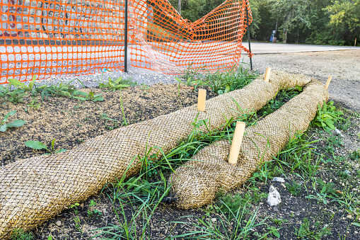 Biodegradable erosion control straw sock guard fixed on construction slope to protect from water runoff erosion