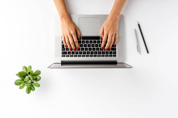 istock Woman’s hands working on laptop on white table with accessories. Business background. Flat lay 1349584056