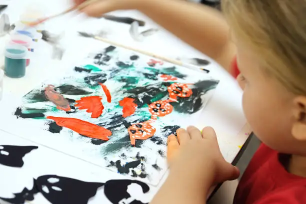 Photo of Child making abstract card for the  halloween. Funny crafts from paper. Halloween decor.