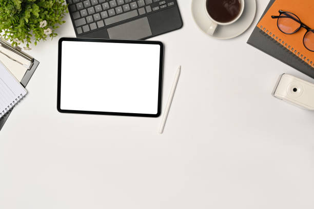 istock Mock up digital tablet with empty display, stylus pen and coffee cup on white table. 1349588152