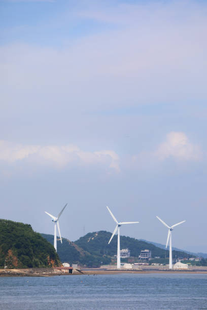 istock Wind power generators in the blue sky and sea. 1349589027