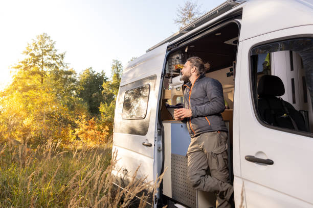 istock Man and his his camper van standing in an autumn scenery 1349591804