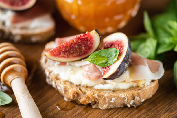 bruschetta con fichi, prosciutto e ricotta - antipasto appetizer basil bread foto e immagini stock