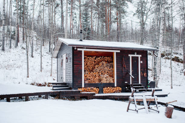 istock Barn with firewoods in snow. Saw and axe near firewoods. 1349600003