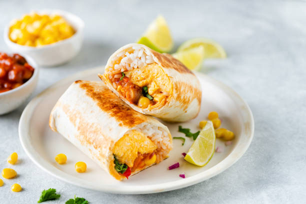 Breakfast tortilla wrap with omelet, beans and vegetables Breakfast tortilla wrap with omelet, beans and vegetables. No meat burrito sandwich burrito stock pictures, royalty-free photos & images