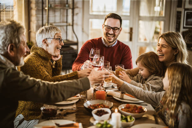 istock Happy multi-generation family toasting while having lunch in dining room. 1349604260