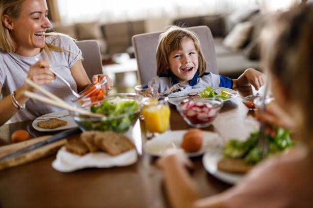 istock Happy single mother having lunch with her kids at home. 1349606829