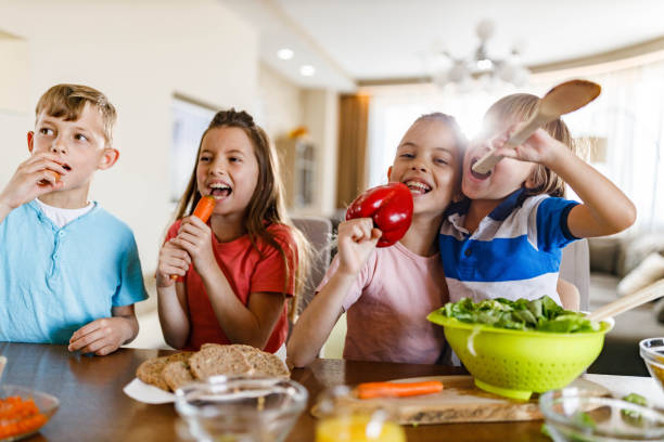 istock Happy siblings having fun while preparing healthy meal for lunch in dining room. 1349607284