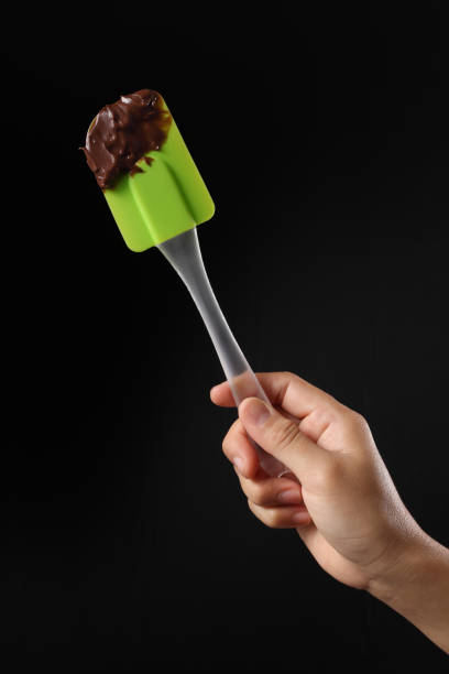 istock Chef holding spatula and melted chocolate isolated on black background 1349608974