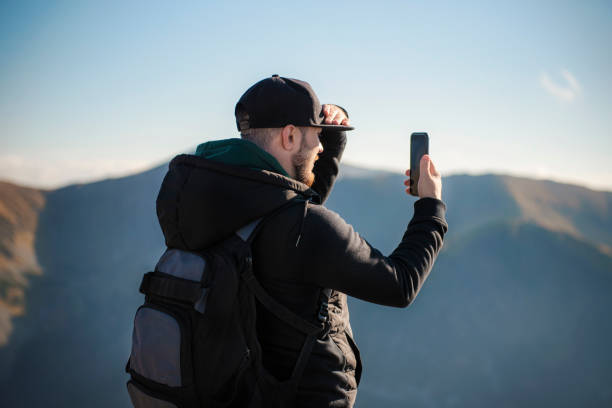 istock Tourist takes on smartphone mountain scenery 1349625916