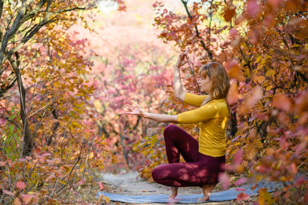 istock Woman meditate and exercise in autumn forest 1349629798